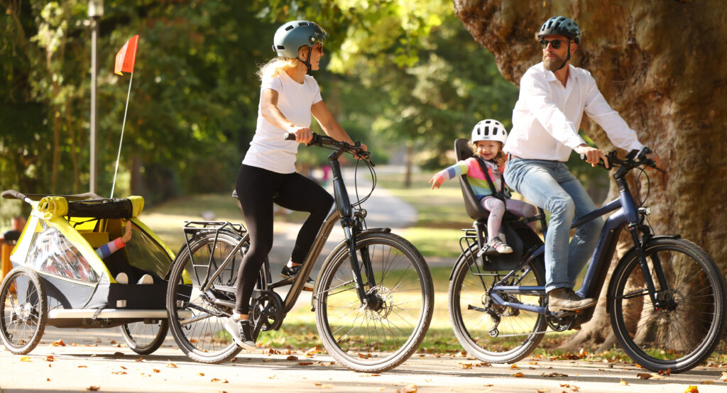 Familie mit Kindern radfahrend im Park.